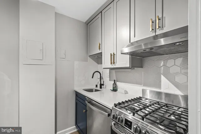 a kitchen with granite countertop a sink stove and cabinets