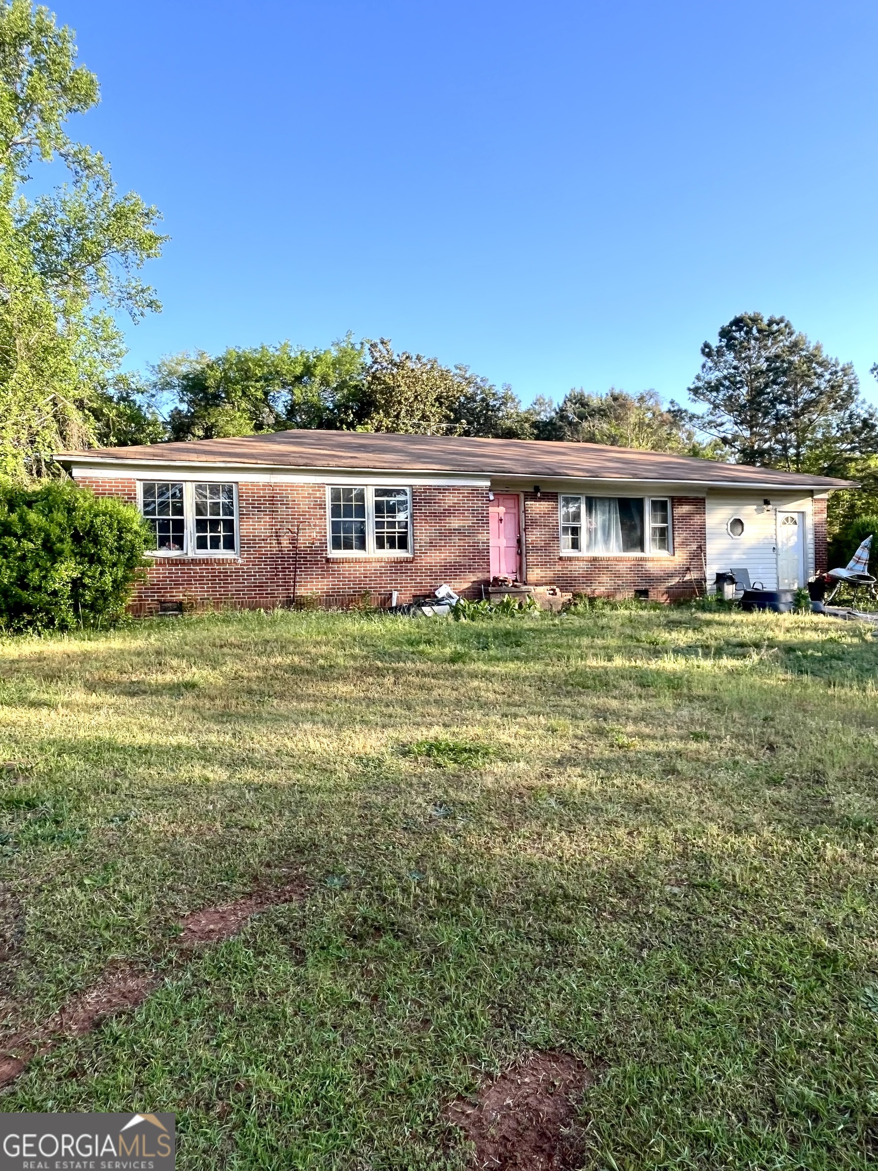 a front view of a house with a garden and trees