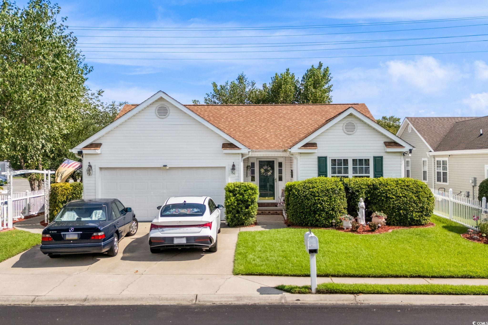 Single story home featuring an attached garage, driveway, and a shingled roof