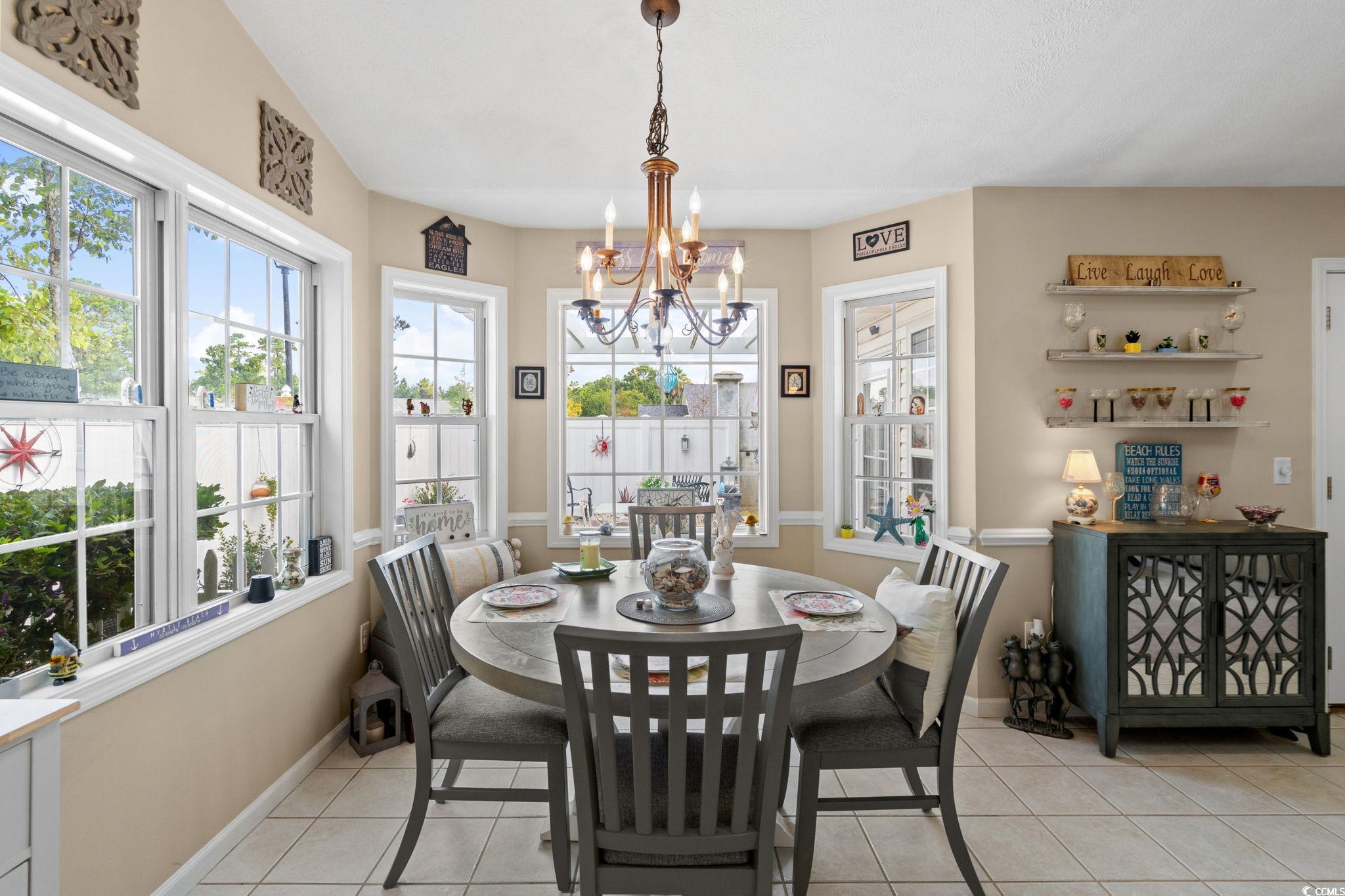 9533 Sullivan Drive Murrells Inlet, SC 29576 - Photo 11 of 40 Dining room with light tile patterned floors and a chandelier
