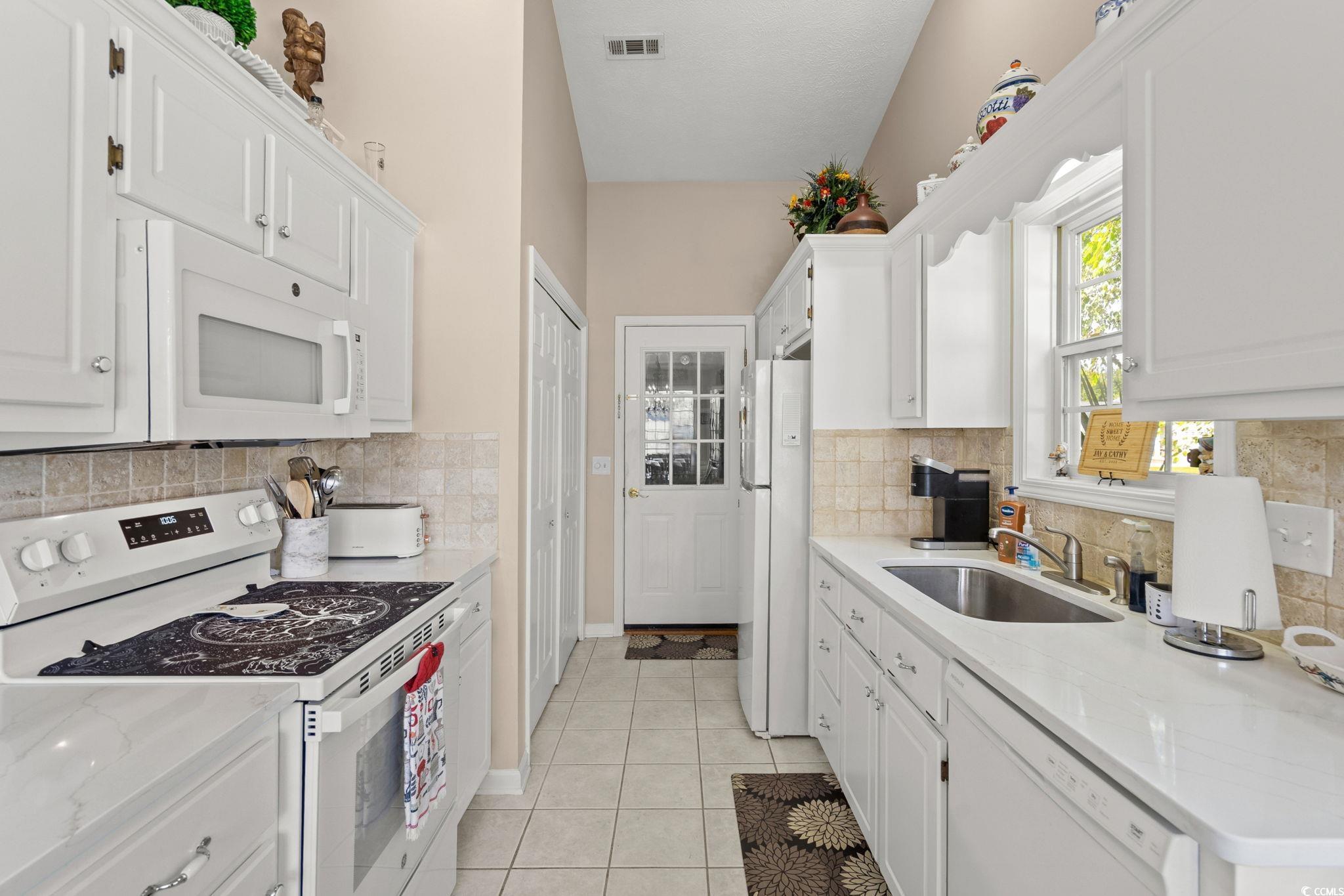 9533 Sullivan Drive Murrells Inlet, SC 29576 - Photo 15 of 40 Kitchen with white appliances, white cabinetry, and light tile patterned floors