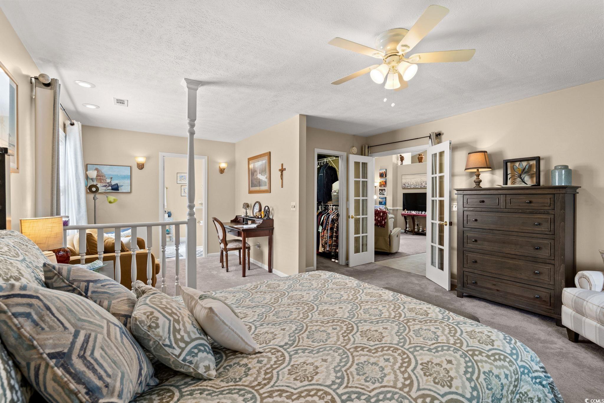 9533 Sullivan Drive Murrells Inlet, SC 29576 - Photo 30 of 40 Bedroom featuring french doors, carpet flooring, a spacious closet, a textured ceiling, and a ceiling fan