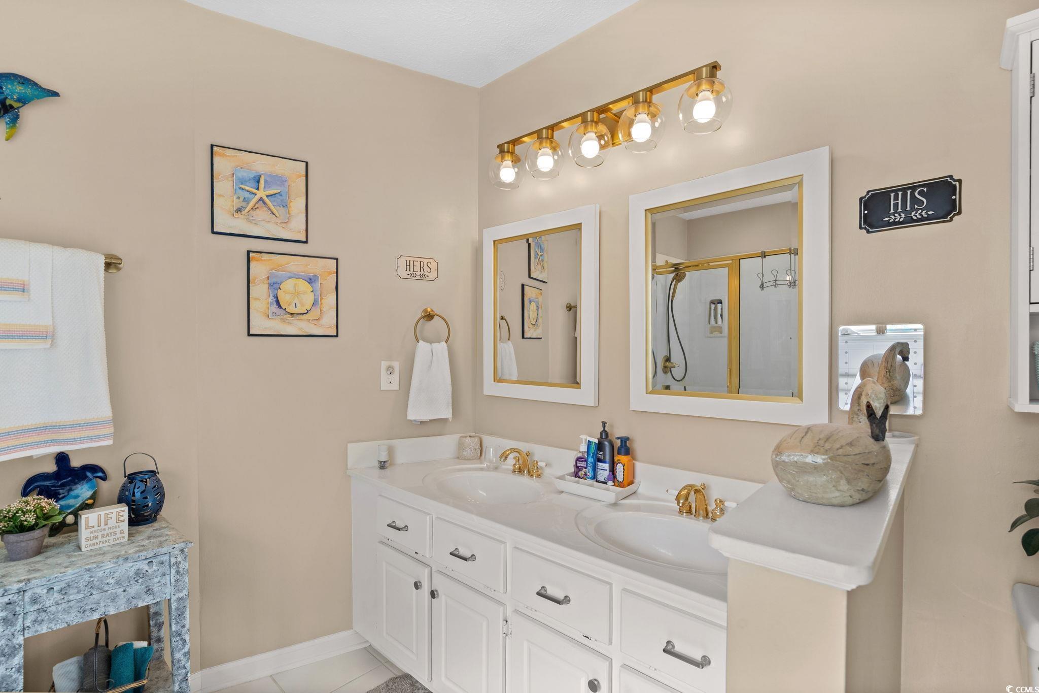 9533 Sullivan Drive Murrells Inlet, SC 29576 - Photo 31 of 40 Bathroom featuring double vanity, a stall shower, and light tile patterned floors