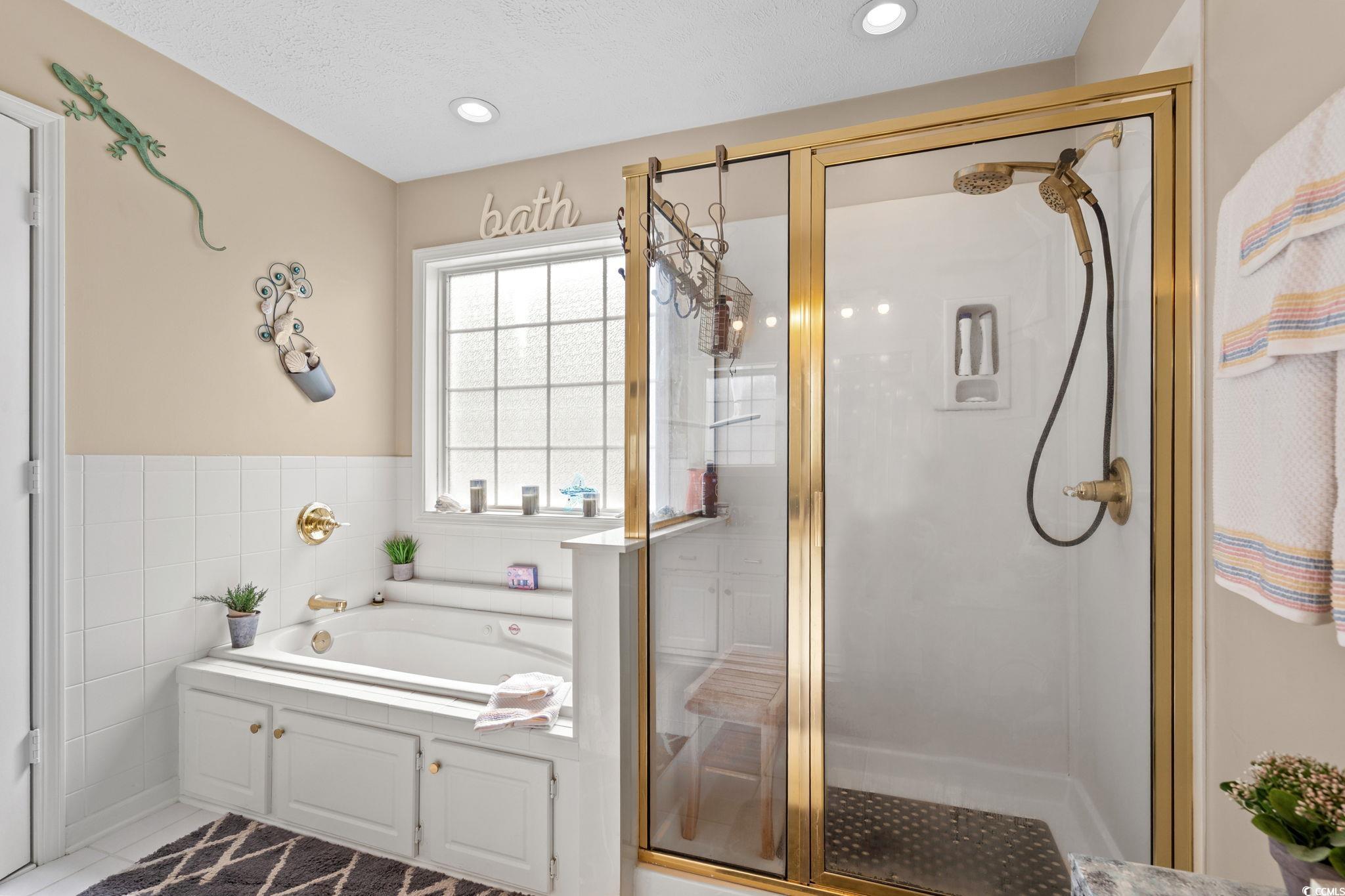 9533 Sullivan Drive Murrells Inlet, SC 29576 - Photo 32 of 40 Bathroom featuring a shower stall, a bath, tile walls, tile patterned flooring, and recessed lighting