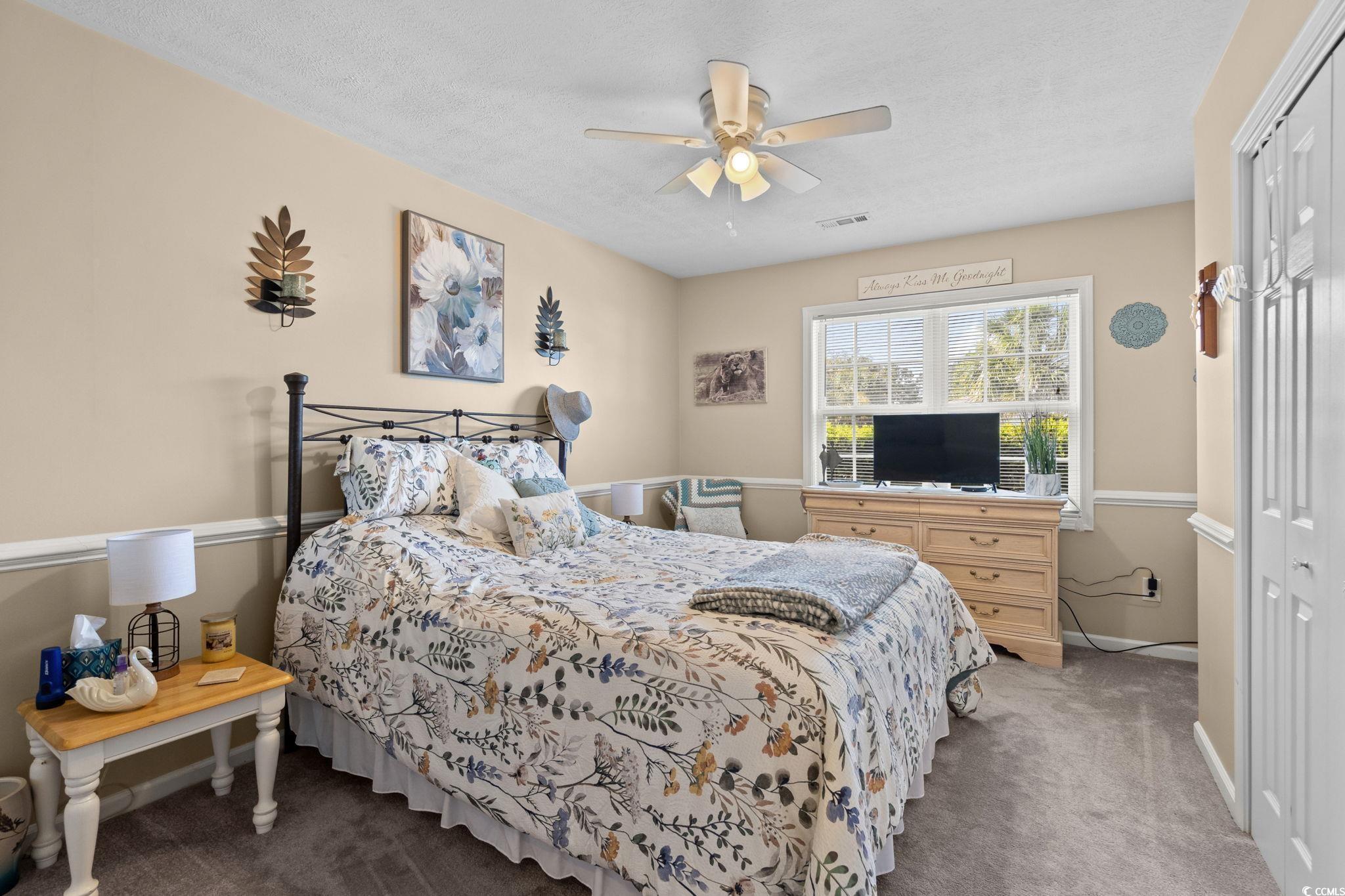 9533 Sullivan Drive Murrells Inlet, SC 29576 - Photo 33 of 40 Bedroom featuring a closet, dark carpet, a ceiling fan, and a textured ceiling