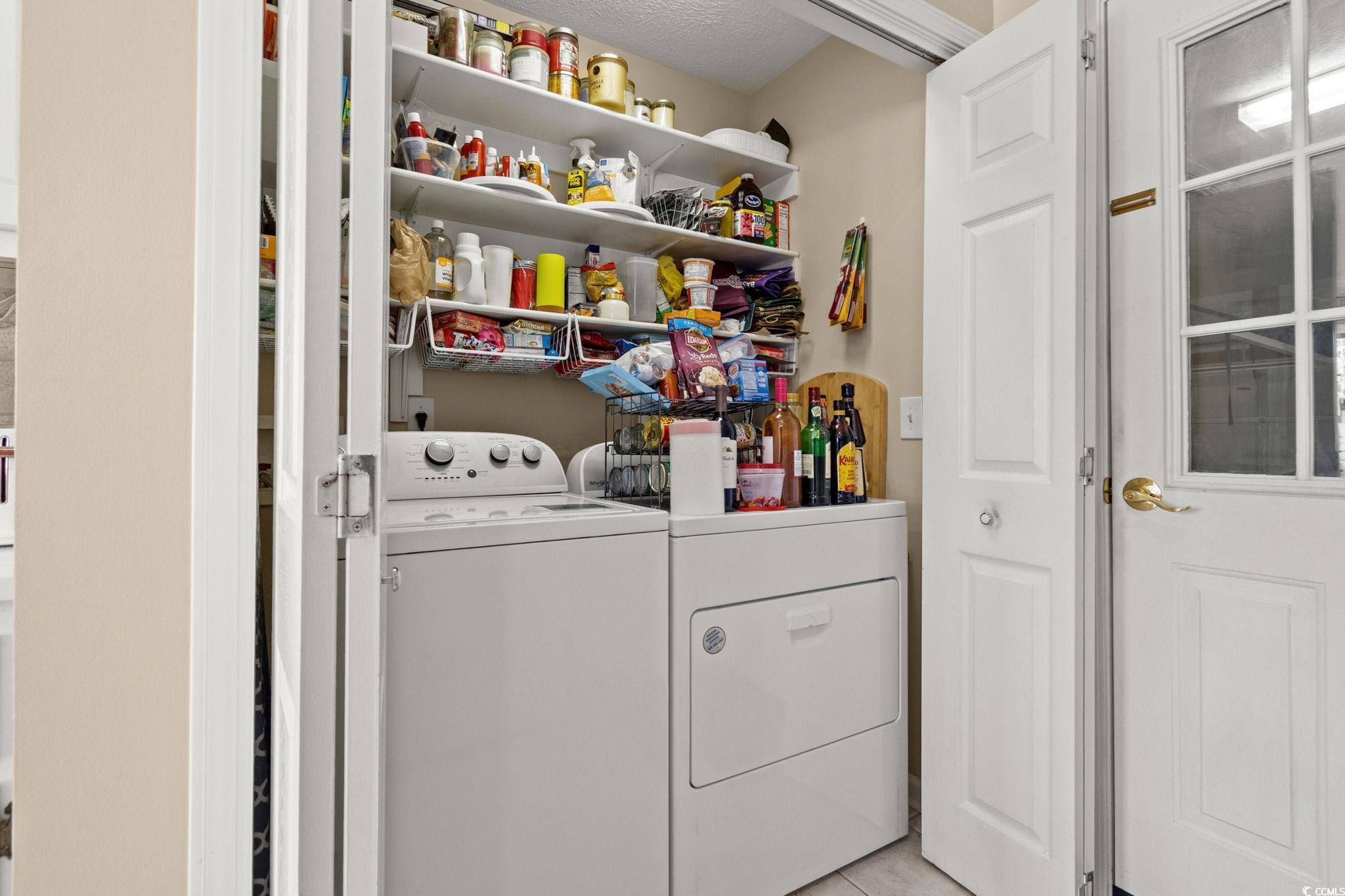 9533 Sullivan Drive Murrells Inlet, SC 29576 - Photo 35 of 40 Washroom featuring washing machine and clothes dryer and light tile patterned flooring