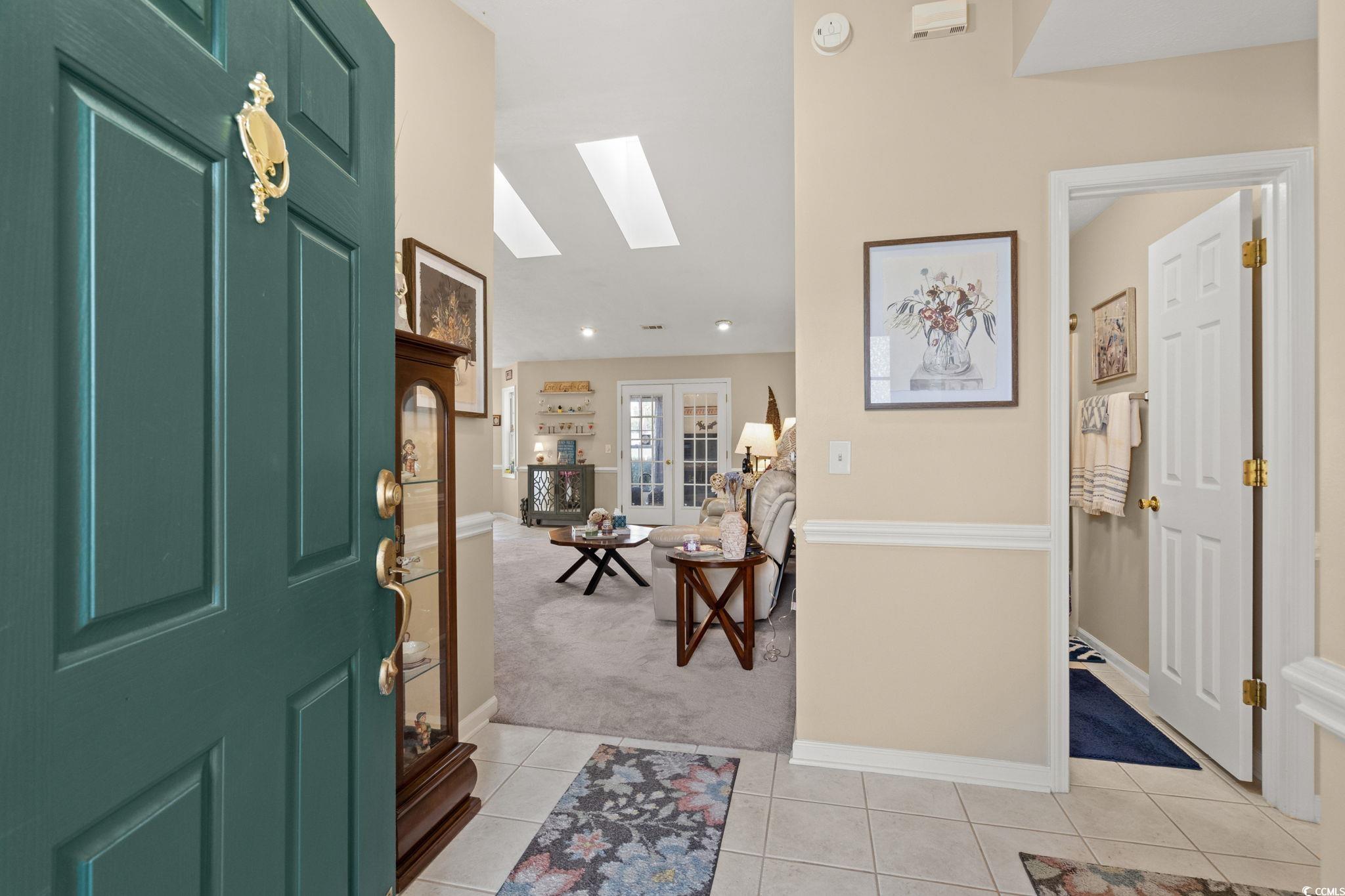 9533 Sullivan Drive Murrells Inlet, SC 29576 - Photo 5 of 40 Foyer entrance featuring a skylight, light tile patterned floors, and light colored carpet