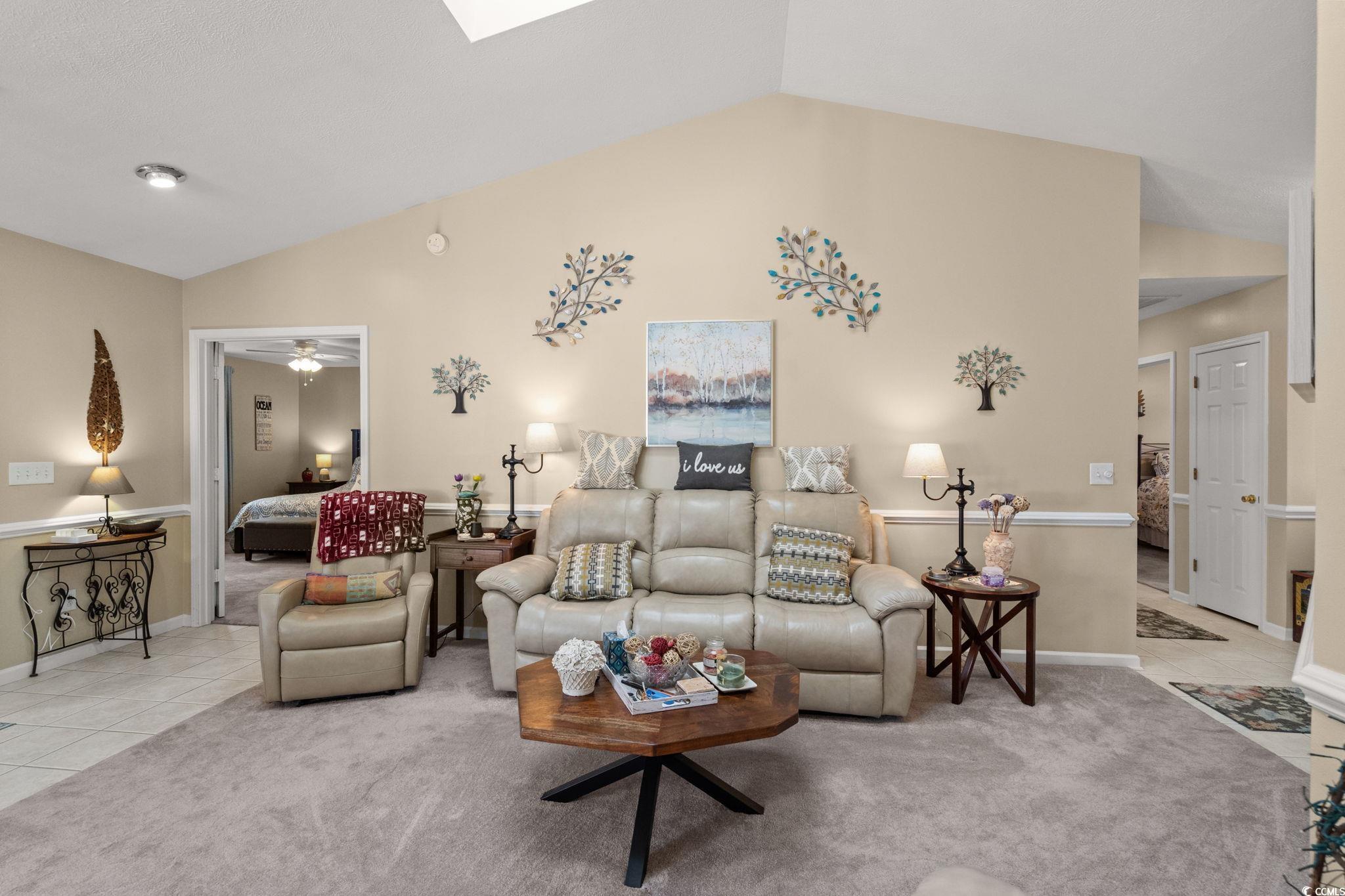 9533 Sullivan Drive Murrells Inlet, SC 29576 - Photo 7 of 40 Living room with vaulted ceiling, tile patterned floors, carpet, a skylight, and a ceiling fan