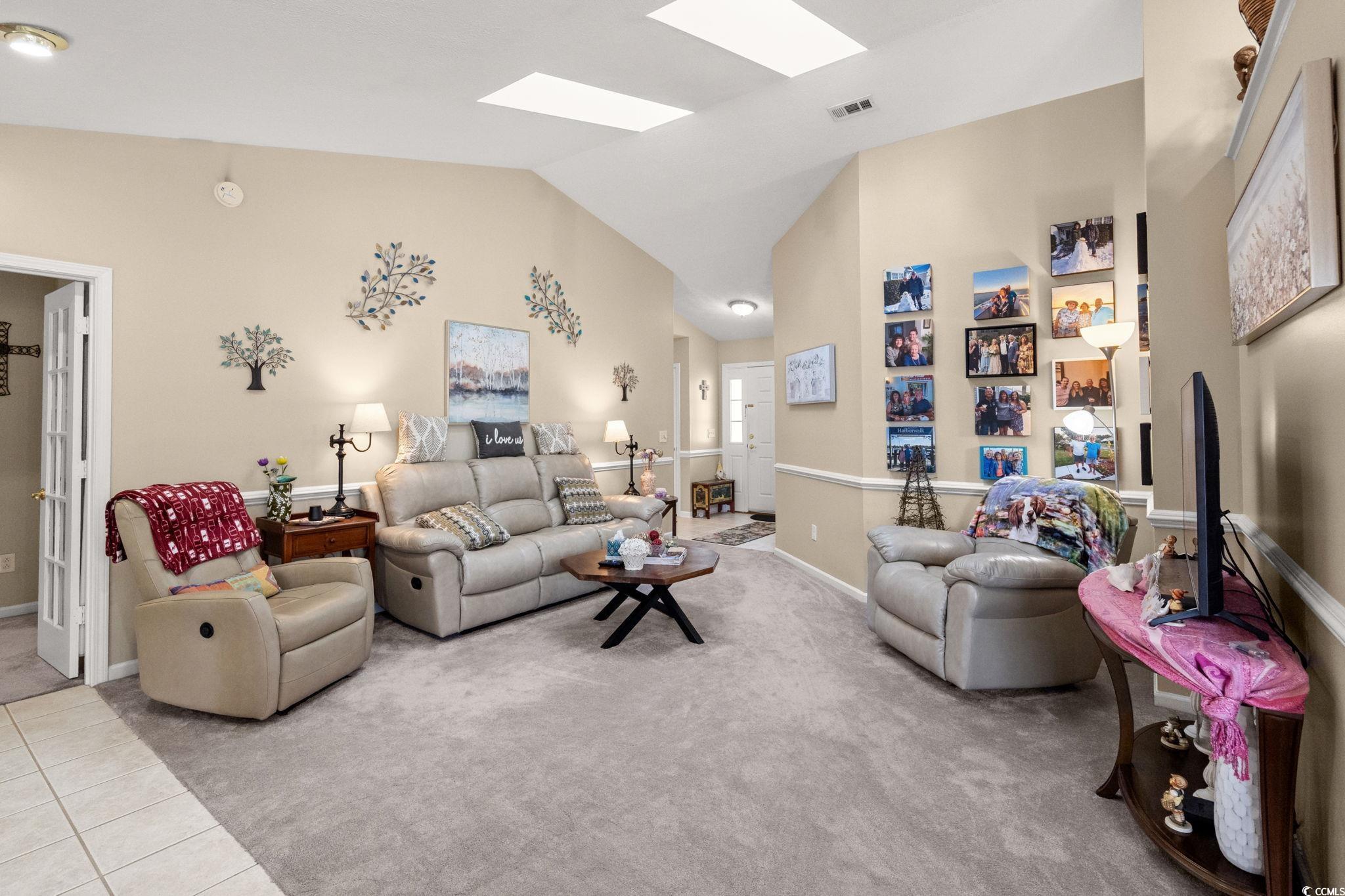 9533 Sullivan Drive Murrells Inlet, SC 29576 - Photo 8 of 40 Living area with light colored carpet, lofted ceiling, a skylight, and light tile patterned floors