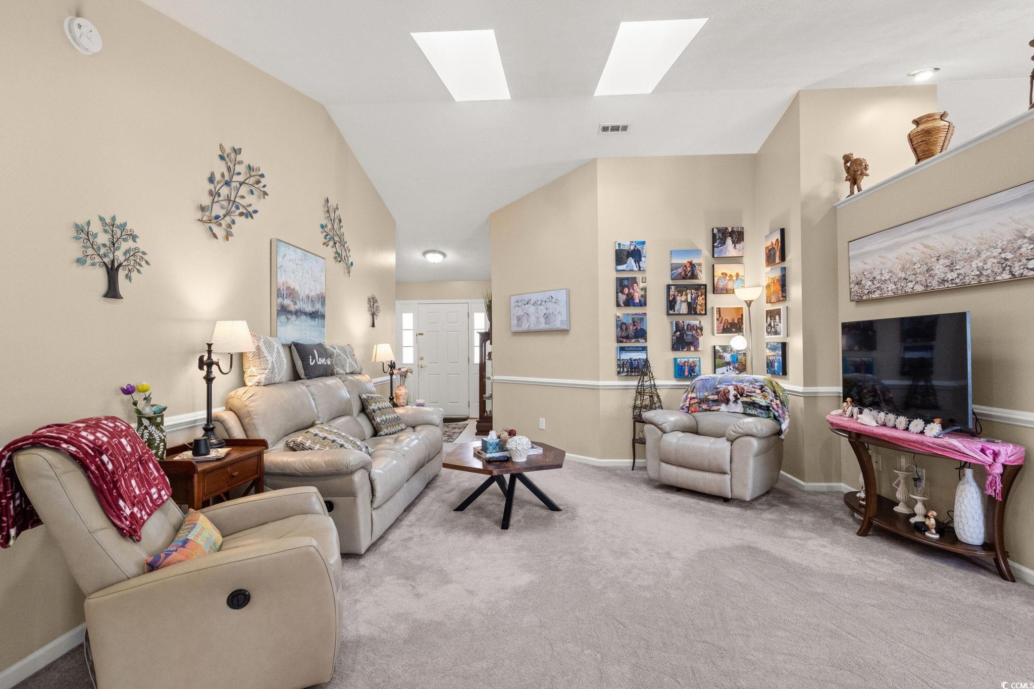9533 Sullivan Drive Murrells Inlet, SC 29576 - Photo 9 of 40 Carpeted living room featuring high vaulted ceiling and a skylight