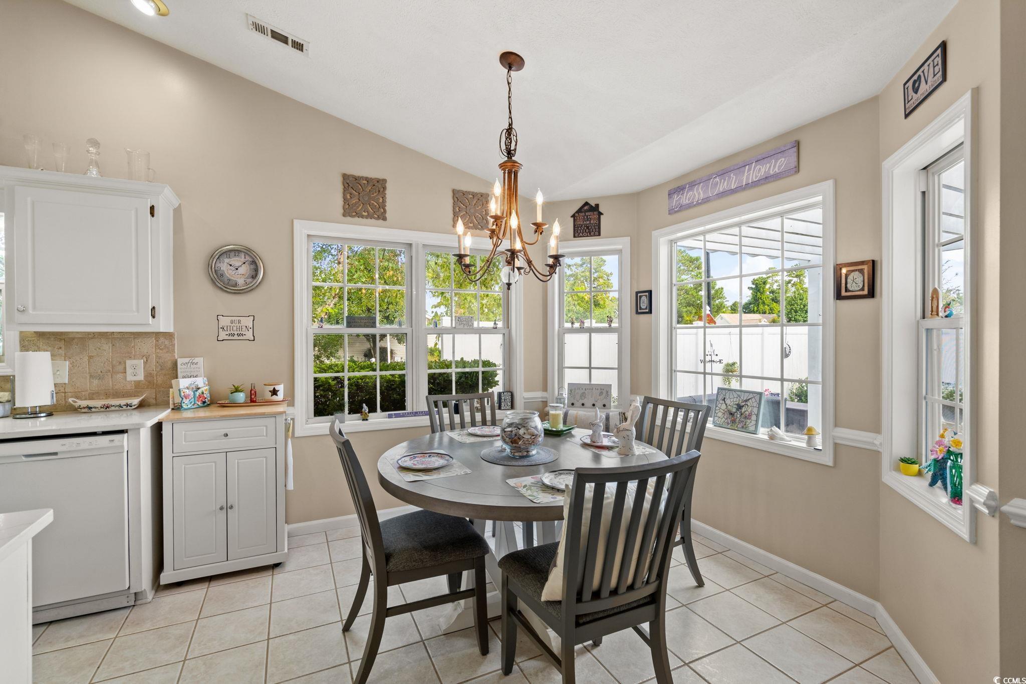 9533 Sullivan Drive Murrells Inlet, SC 29576 - Photo 10 of 40 Dining area featuring vaulted ceiling, light tile patterned floors, and a chandelier