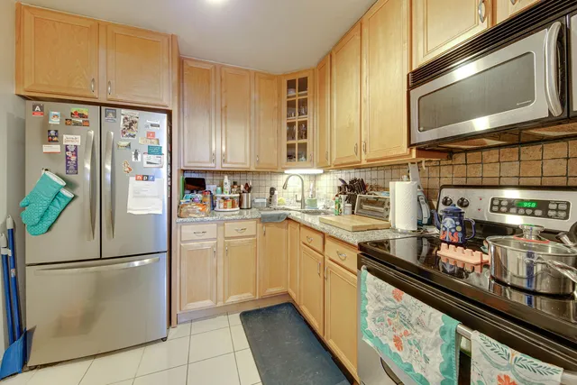 a kitchen with stainless steel appliances a refrigerator sink and microwave