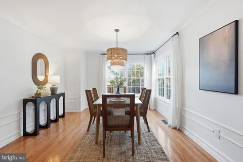 a dining room with furniture a chandelier and wooden floor