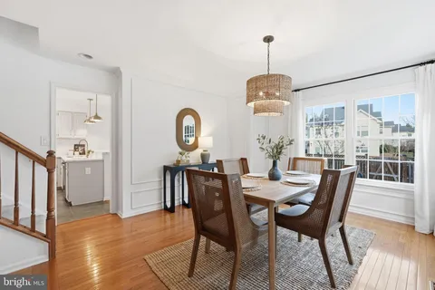 a dining room with furniture a chandelier and wooden floor