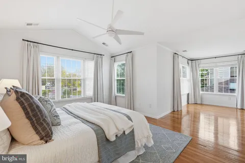 a spacious bedroom with a large bed and a wooden floor