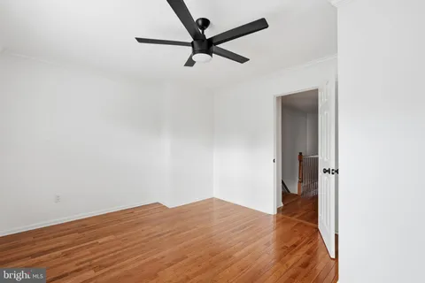 a view of a room with wooden floor and a ceiling fan