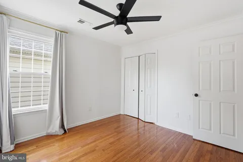 a view of a livingroom with wooden floor and a ceiling fan