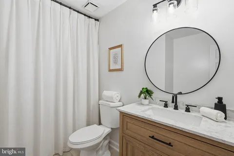 a bathroom with a sink a toilet and a mirror