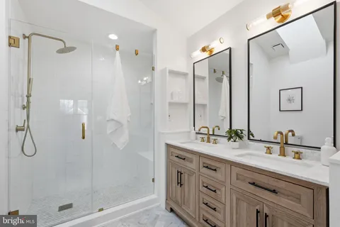 a bathroom with a double vanity sink mirror and shower