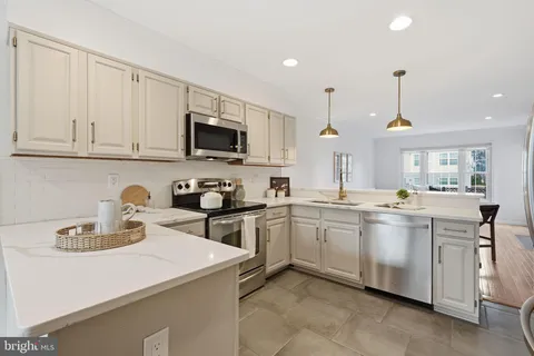 a kitchen with cabinets a sink and appliances