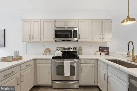 a kitchen with white cabinets and white appliances