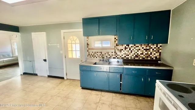 a kitchen with granite countertop a sink and a stove