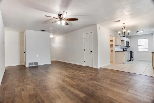 a view of a livingroom with a ceiling fan wooden floor and a ceiling fan