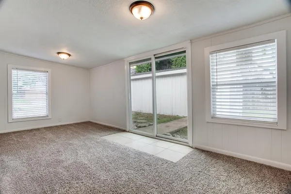 a view of an empty room with window wooden floor and windows