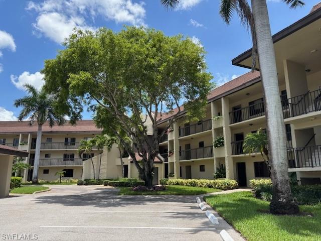 413 Augusta Boulevard, Unit 306 Naples, FL 34113 - Photo 1 of 31 a front view of a building with a garden and plants