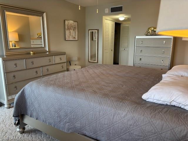 413 Augusta Boulevard, Unit 306 Naples, FL 34113 - Photo 14 of 31 a bedroom with a bed and a dresser