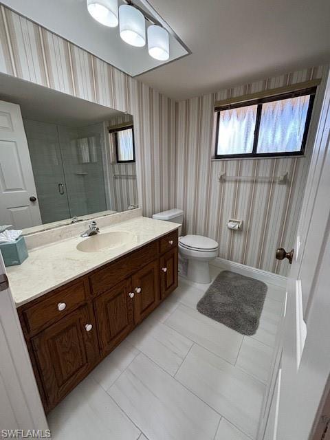 413 Augusta Boulevard, Unit 306 Naples, FL 34113 - Photo 16 of 31 a spacious bathroom with a double vanity sink a toilet and a mirror