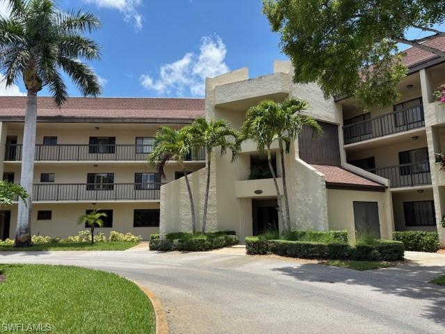 413 Augusta Boulevard, Unit 306 Naples, FL 34113 - Photo 2 of 31 a front view of a house with a yard and a garage