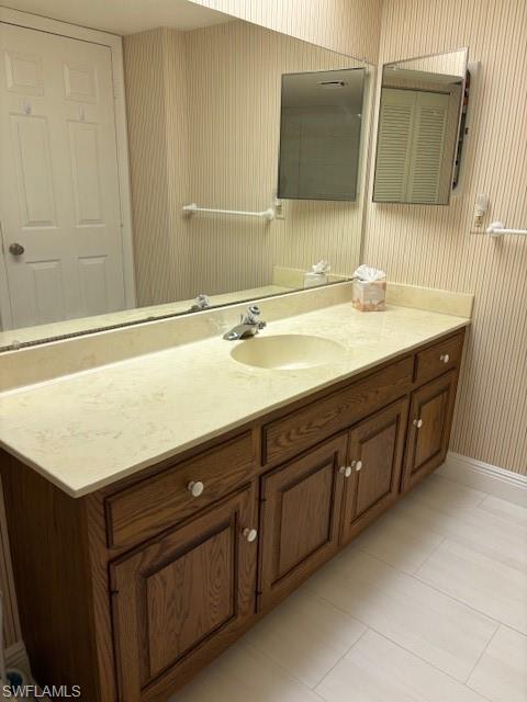 413 Augusta Boulevard, Unit 306 Naples, FL 34113 - Photo 21 of 31 a bathroom with a sink and a mirror