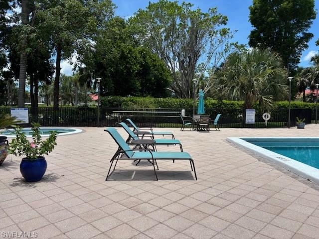 413 Augusta Boulevard, Unit 306 Naples, FL 34113 - Photo 31 of 31 a view of patio with table and chairs potted plants and large trees