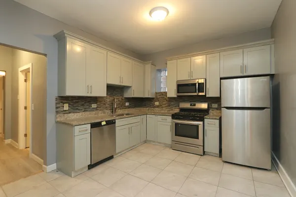 a kitchen with stainless steel appliances granite countertop a stove a refrigerator and a microwave