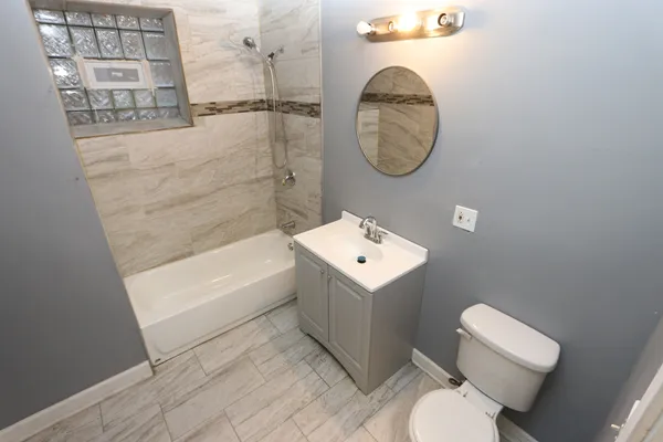 a bathroom with a toilet a sink and a mirror