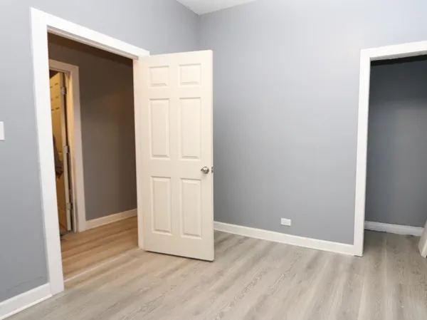 an empty room with wooden floor and closet