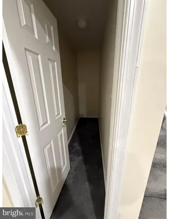 a view of an empty room with closet and a window