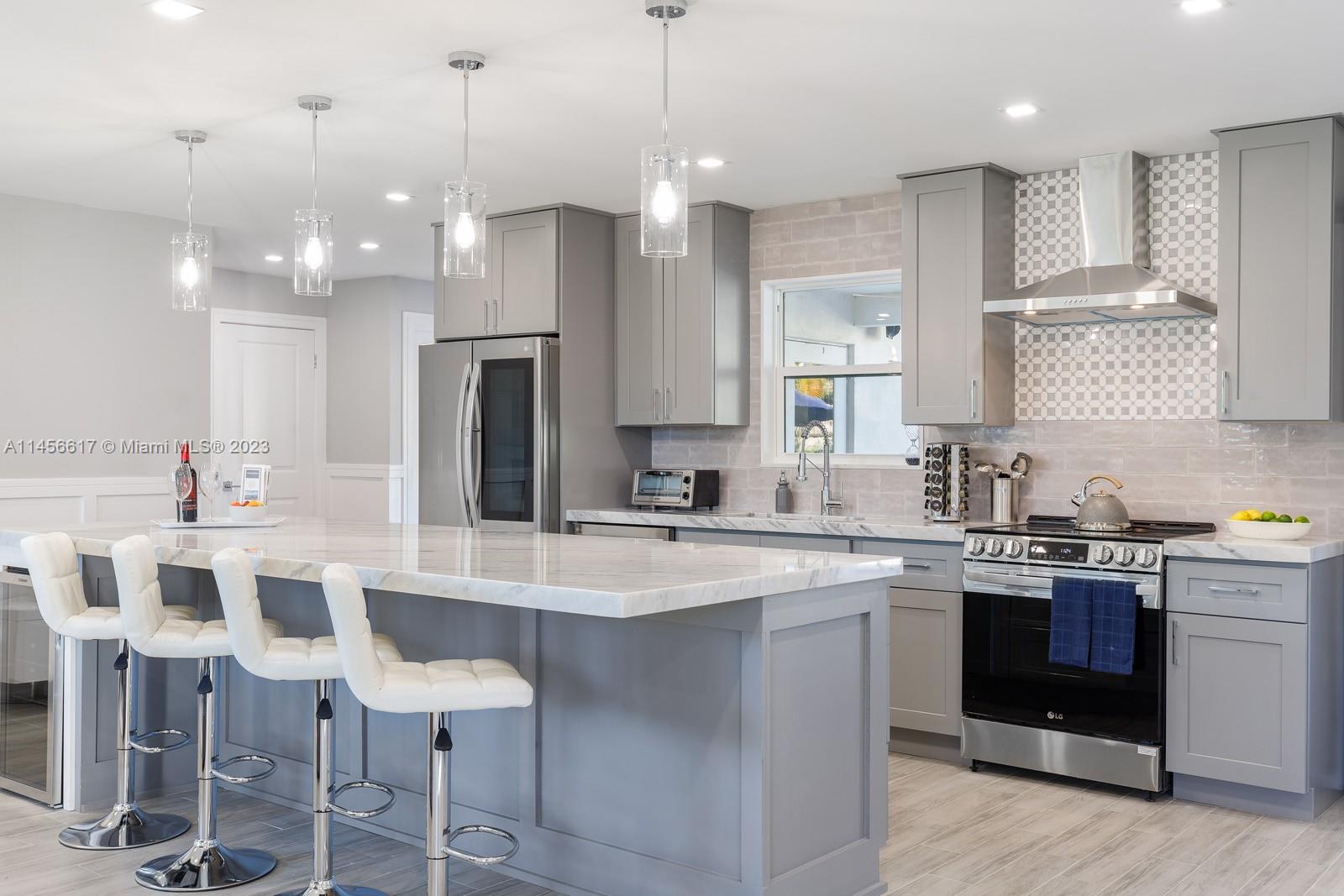 a large kitchen with a kitchen island white cabinets and stainless steel appliances