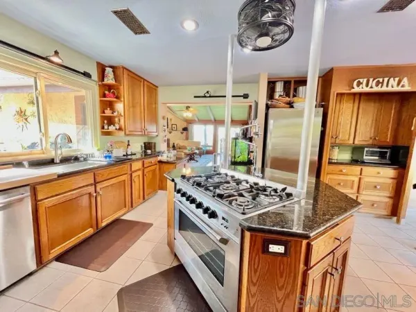 a kitchen with stainless steel appliances granite countertop a stove a sink and a microwave