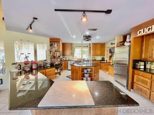 a living room with stainless steel appliances kitchen island granite countertop furniture and a rug
