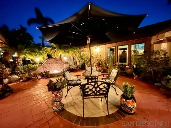 a view of a patio with table and chairs potted plants