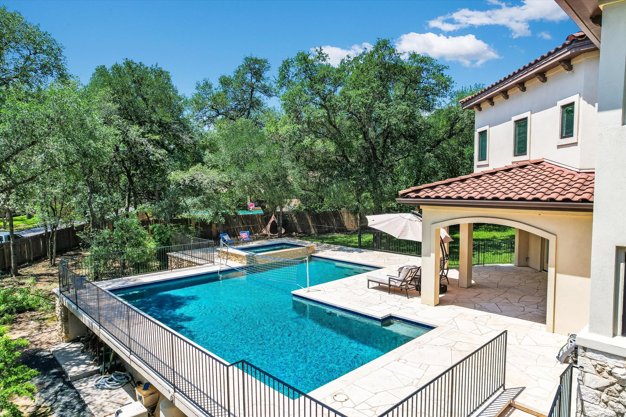 11 Inwood Circle Austin, TX 78746 - Photo 33 of 38 An inviting pool area with a spa, offering serene relaxation amidst mature trees and a charming covered patio.