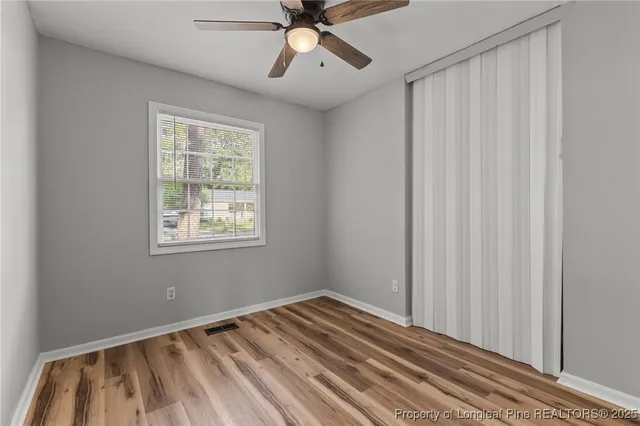 a view of a room with wooden floor and windows