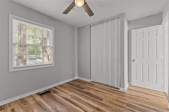 a view of a room with a ceiling fan and a window