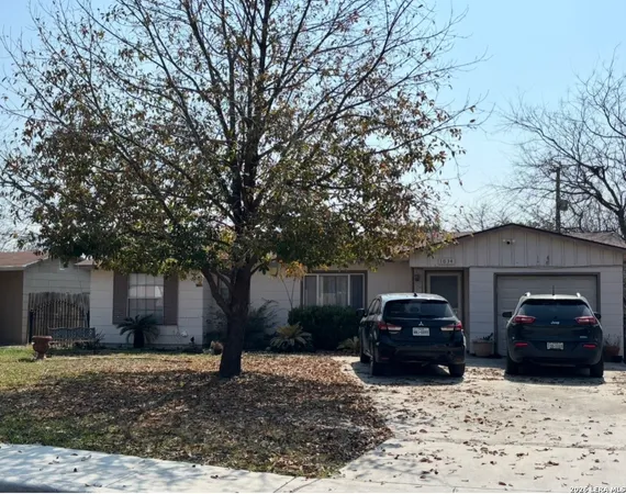 a front view of a house with cars parked