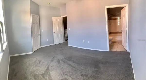 an empty room with closet and windows