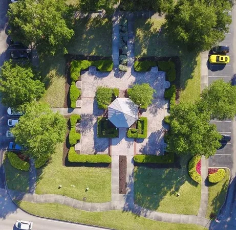 a aerial view of a house with a yard and large trees