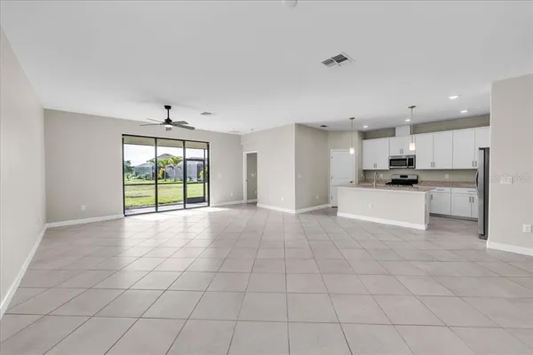 a view of a livingroom with a ceiling fan & entryway