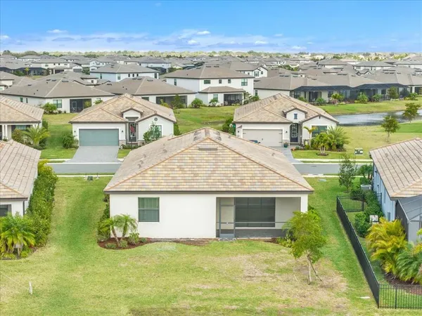 an aerial view of residential houses with outdoor space and ocean view